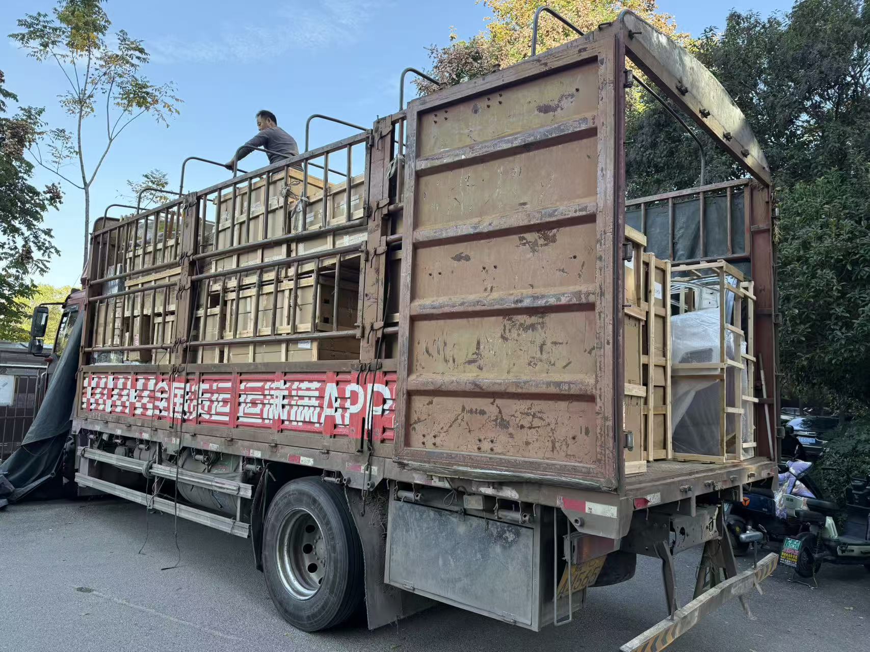 Crated auto parts being loaded onto a delivery truck